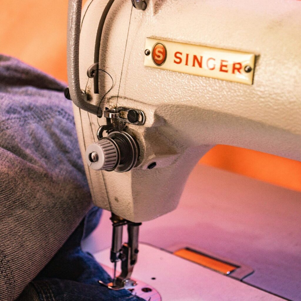Detailed view of a Singer sewing machine working on denim fabric with precision.