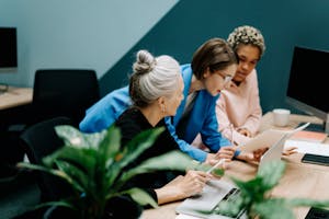 A diverse group of professionals collaborate on a project in a modern office environment.