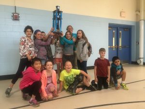 2018 Recycle Rally winners at C.P Smith Elementary School holding up their trophy in the gym.